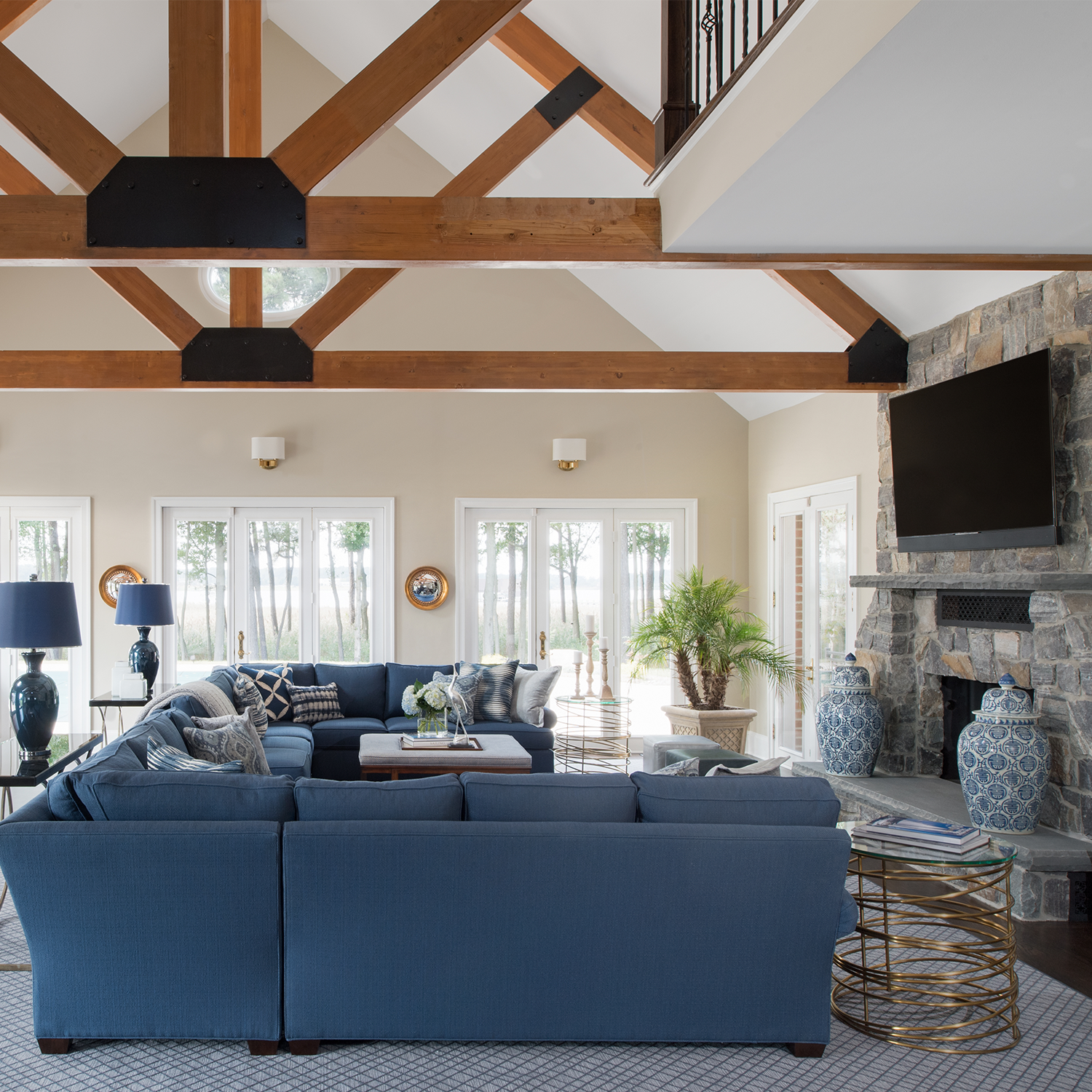 Great room with vaulted ceilings, wood beams, and blue sectional