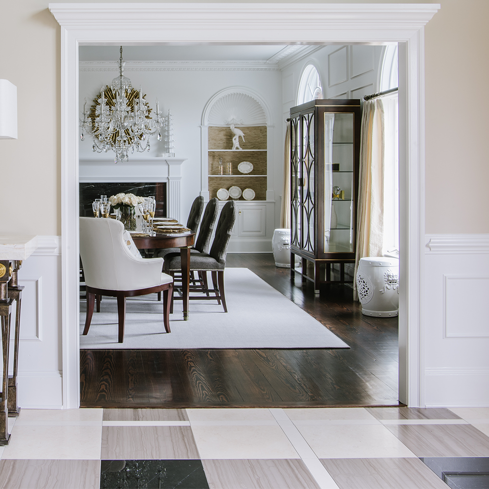 view from entry into formal dining room showing different types of flooring including plaid marble, white area rug, and dark hardwood floors | Bountiful Flooring, Easton, MD