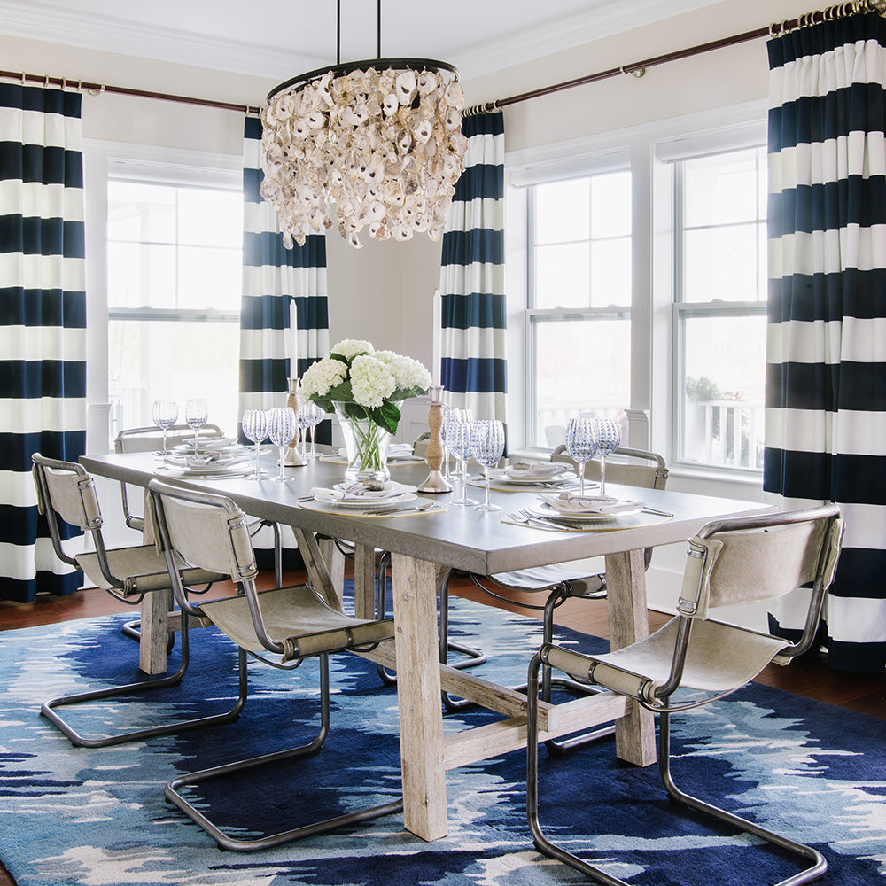 Blue and white dining room design by Jamie Merida Interiors - shows dining table, chairs, and oyster chandelier