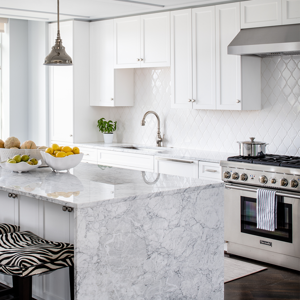 white kitchen with white arabesque backsplash tile and grey and white quartz countertop. Products from Bountiful Flooring.